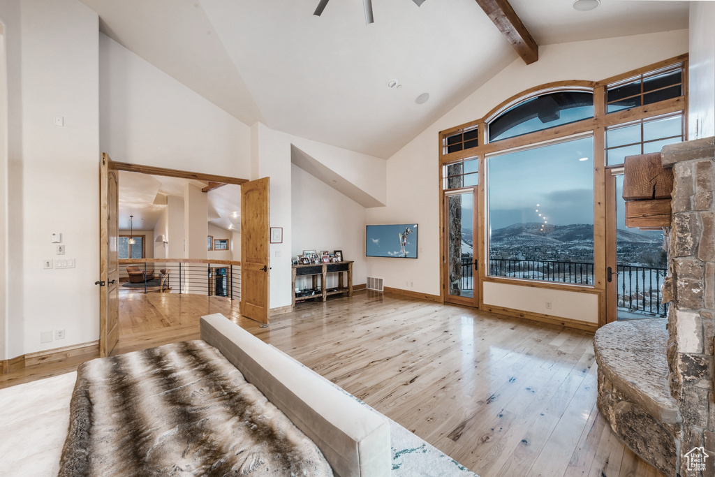 Interior space featuring high vaulted ceiling, wood-type flooring, beamed ceiling, and a mountain view