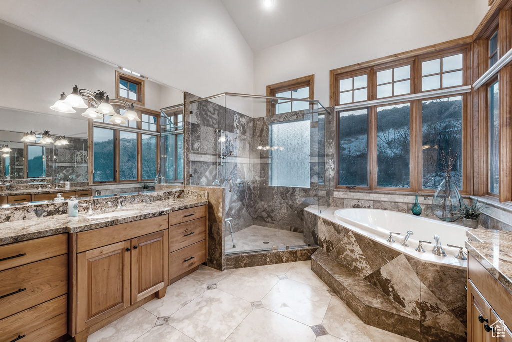 Bathroom with a towering ceiling, tile flooring, large vanity, and shower with separate bathtub