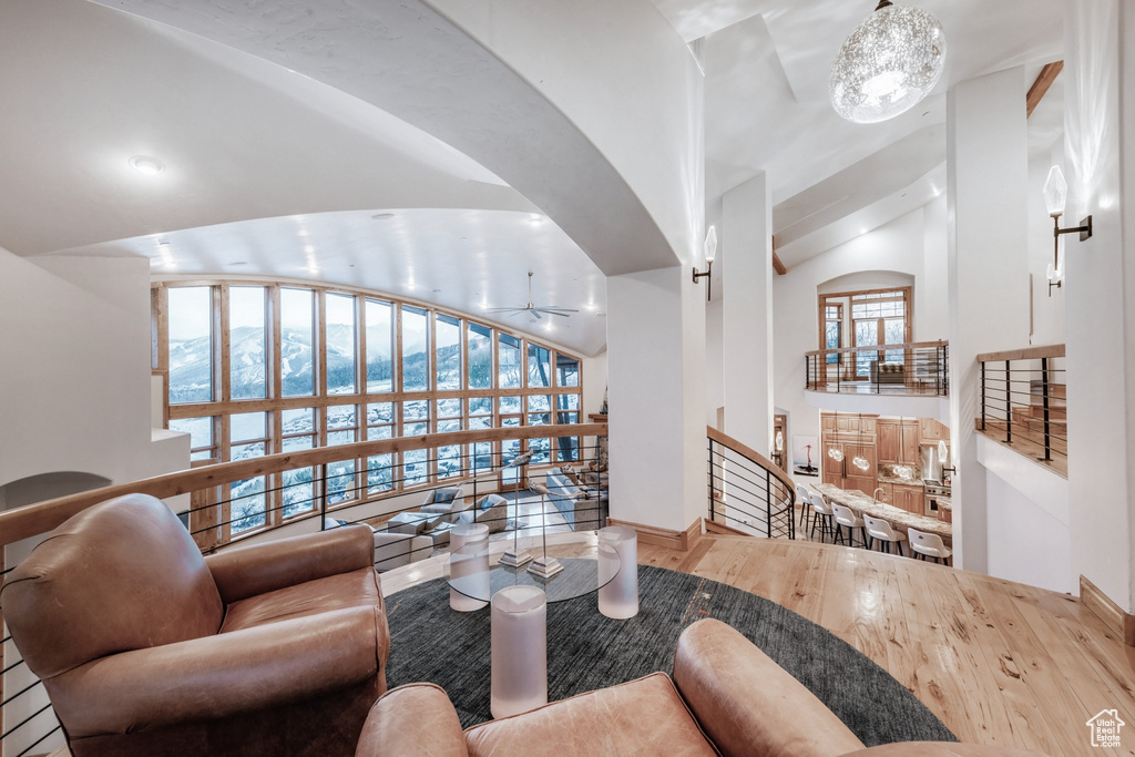 Living room with an inviting chandelier, hardwood / wood-style flooring, and lofted ceiling