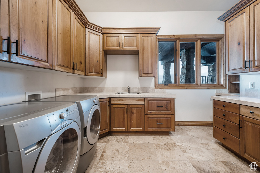 Laundry room featuring cabinets, washer and clothes dryer, hookup for a washing machine, sink, and light tile floors