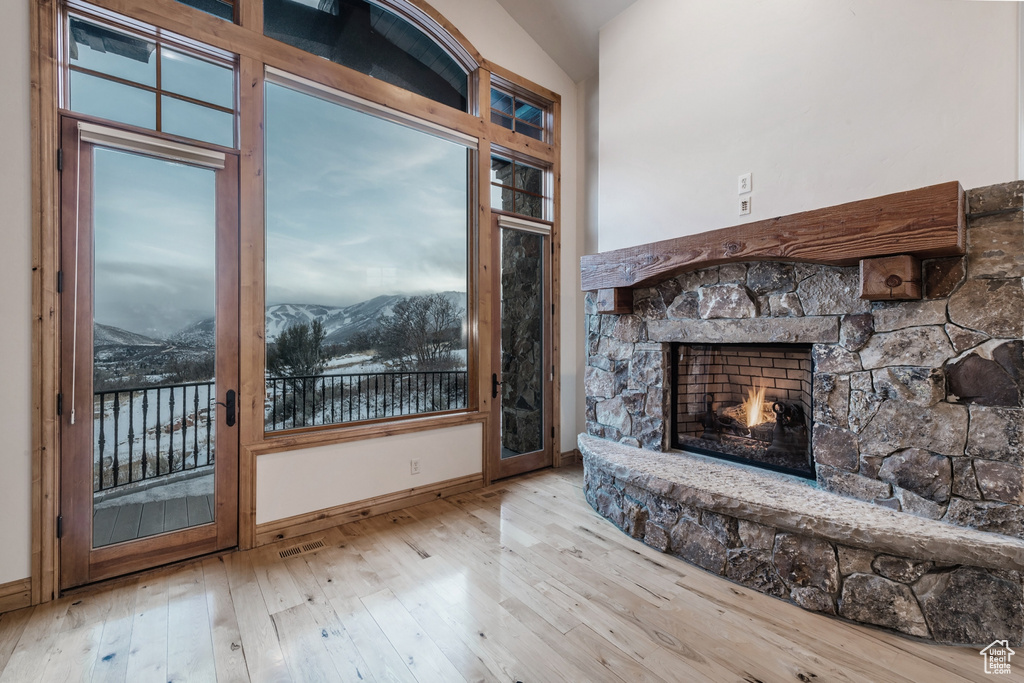 Unfurnished living room featuring a mountain view, a fireplace, and wood-type flooring