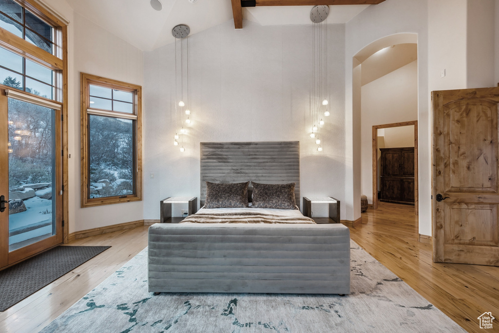 Bedroom featuring high vaulted ceiling, hardwood / wood-style floors, and beam ceiling