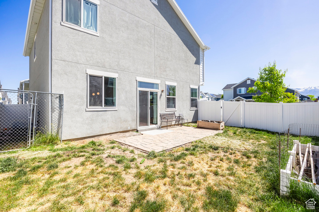 Back of house featuring a patio area and a lawn