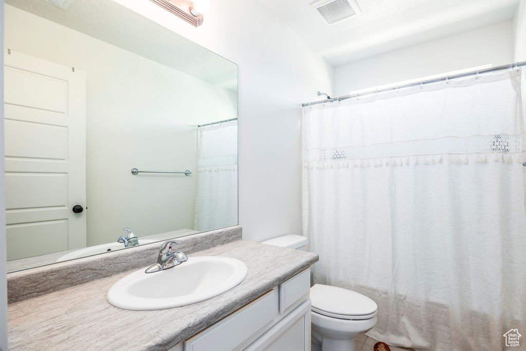 Bathroom with tile flooring, vanity, and toilet