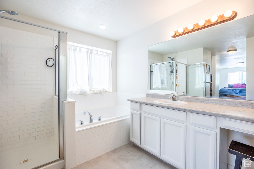 Bathroom with tile flooring, independent shower and bath, and large vanity