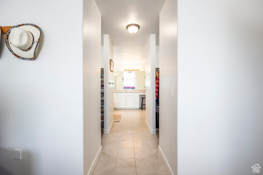 Corridor featuring light tile flooring