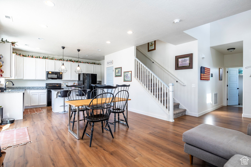 Dining area with sink and wood-type flooring