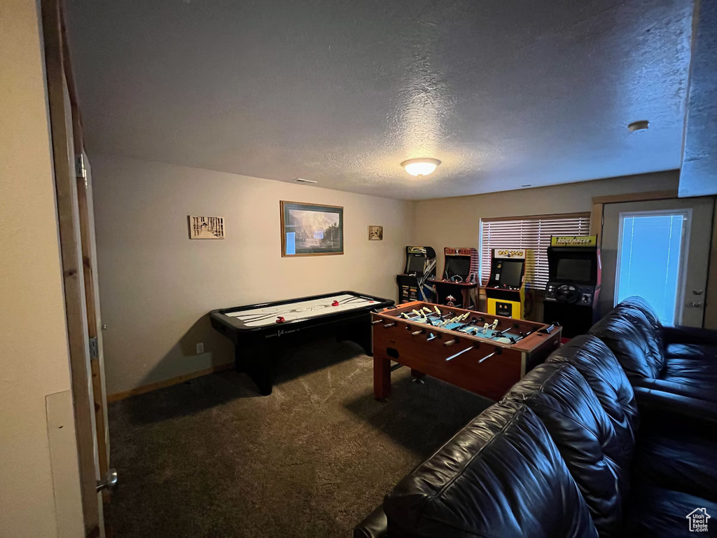 Interior space with dark colored carpet and a textured ceiling
