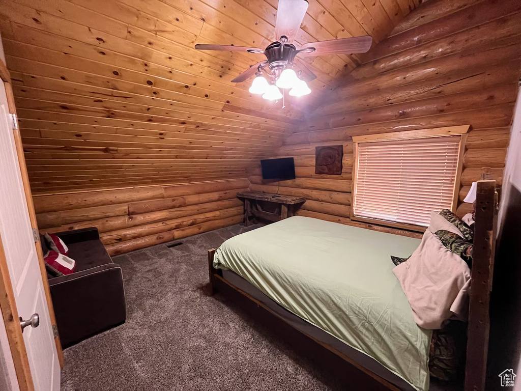 Carpeted bedroom with ceiling fan, vaulted ceiling, log walls, and wood ceiling