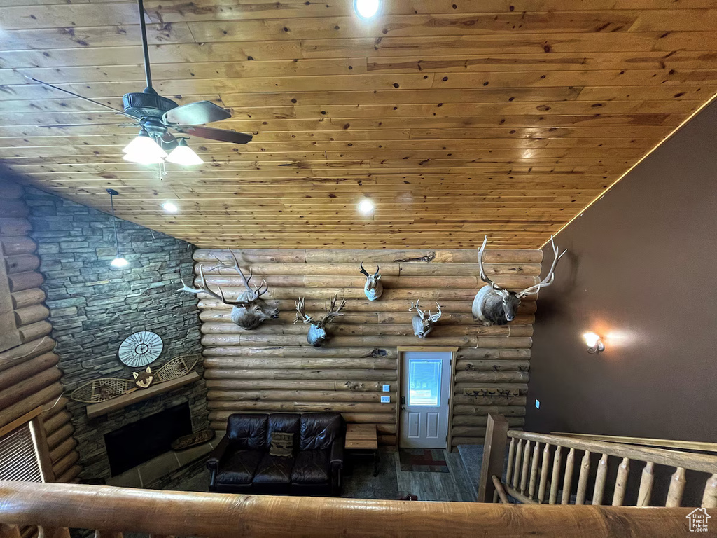 Unfurnished living room featuring lofted ceiling, dark hardwood / wood-style floors, and log walls