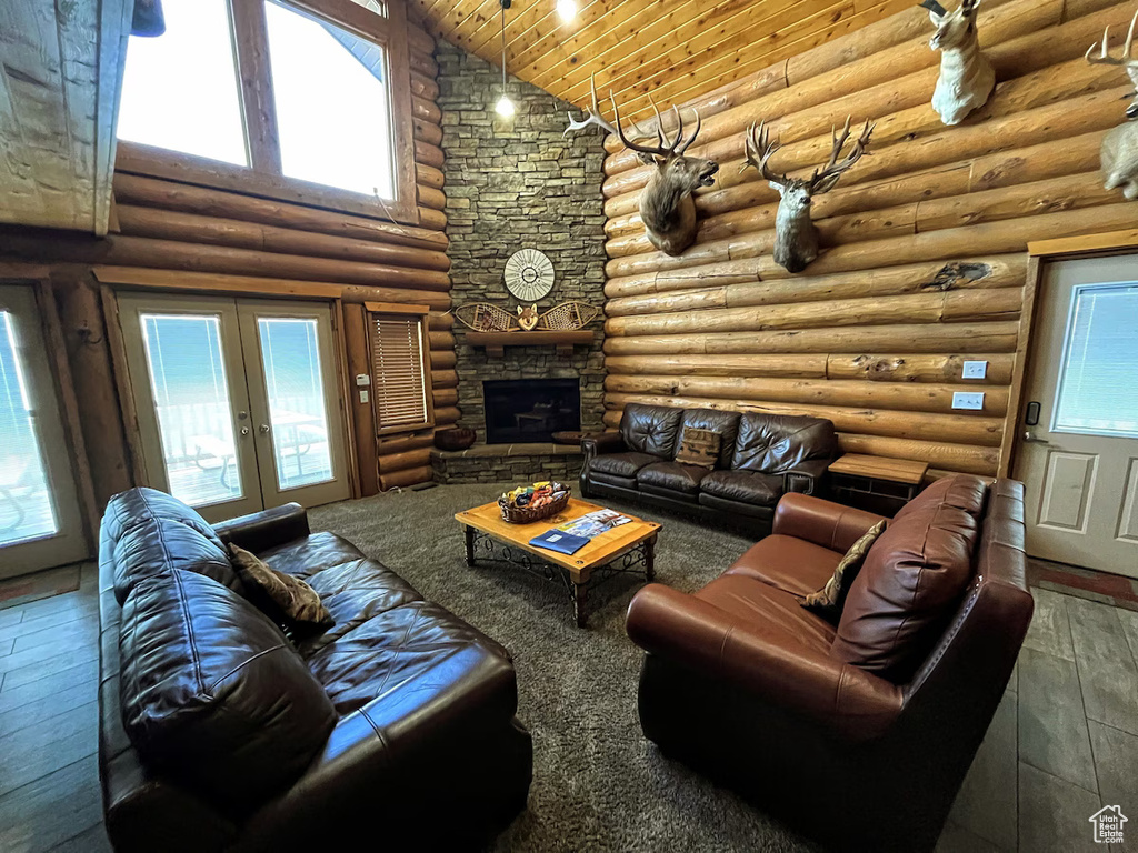 Living room with a healthy amount of sunlight, french doors, high vaulted ceiling, and wood-type flooring