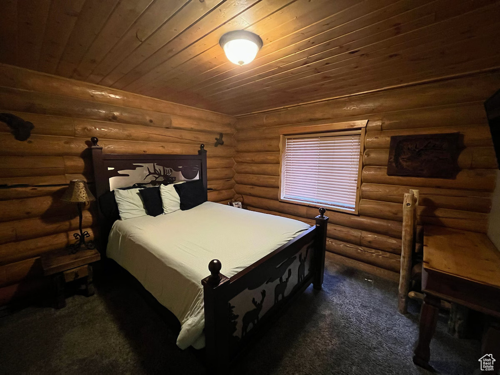 Carpeted bedroom with wooden ceiling and rustic walls