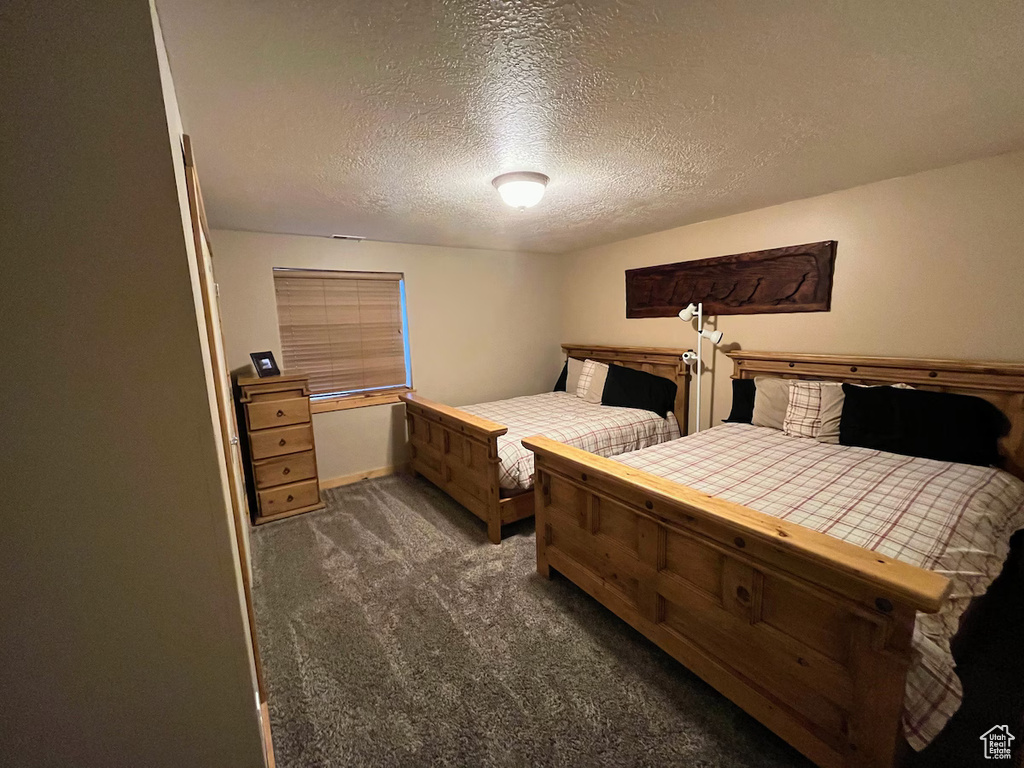 Carpeted bedroom with a textured ceiling