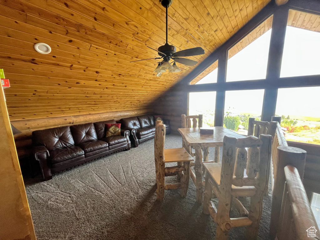 Unfurnished dining area with high vaulted ceiling, carpet flooring, wood ceiling, and ceiling fan