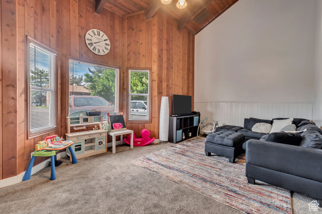 Living room with carpet floors, beamed ceiling, wood ceiling, wooden walls, and high vaulted ceiling