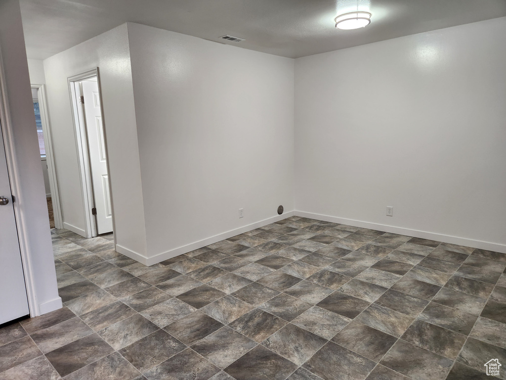 Unfurnished room with dark tile floors