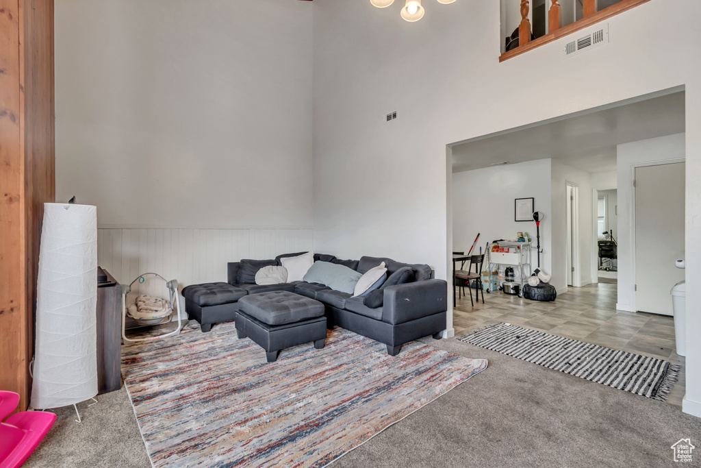 Living room with carpet flooring and a towering ceiling