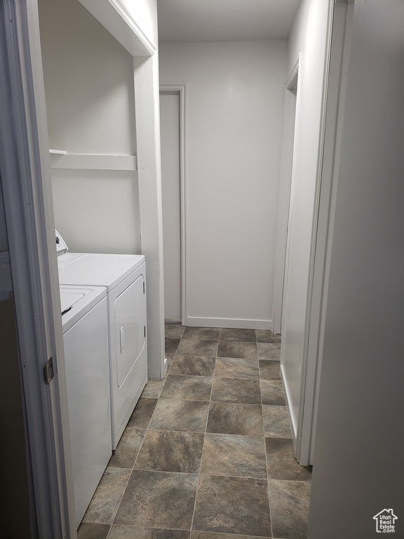 Laundry area featuring washer and clothes dryer and dark tile floors