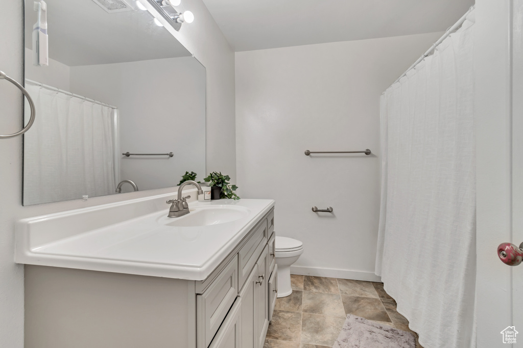 Bathroom featuring tile flooring, toilet, and oversized vanity