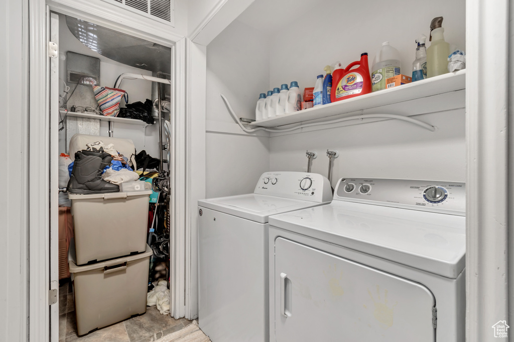 Laundry room with washer and dryer, light tile flooring, and washer hookup