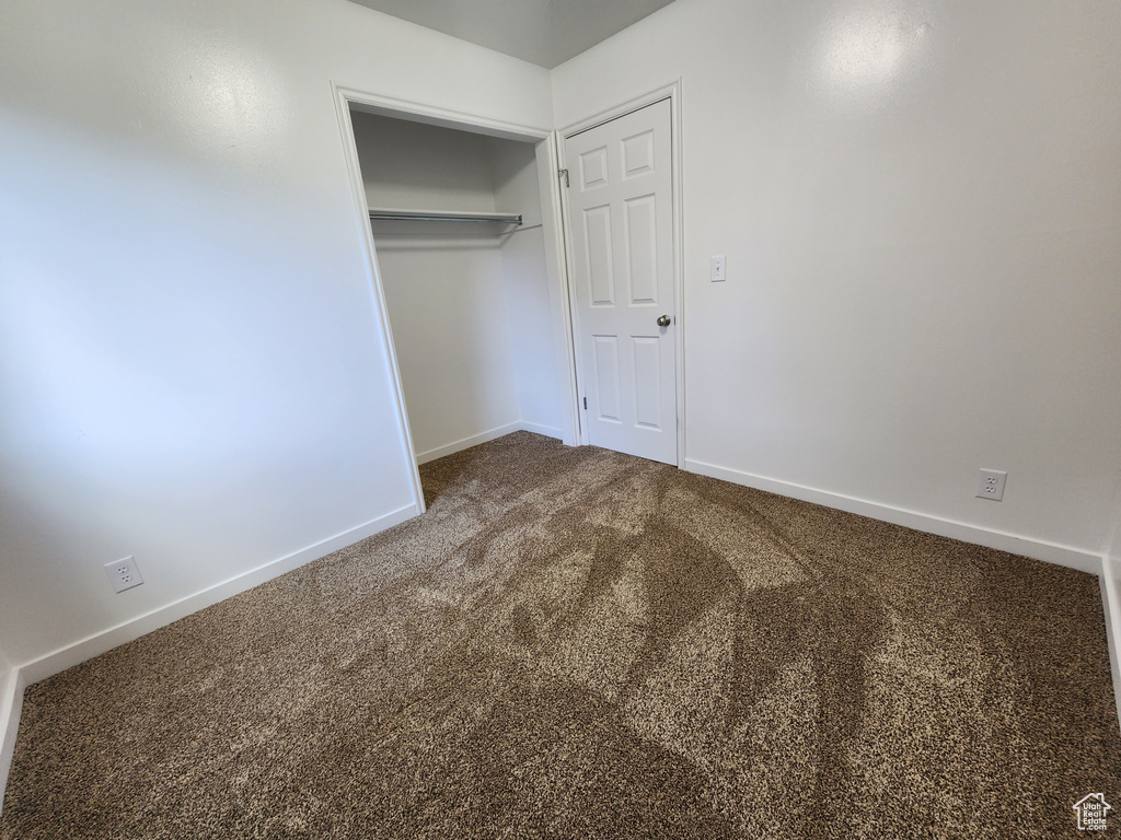 Unfurnished bedroom featuring carpet and a closet