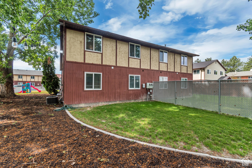 Back of property with a yard and central AC unit