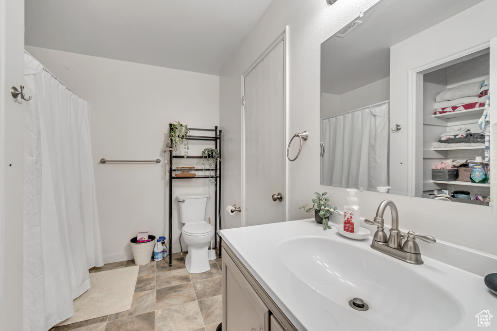 Bathroom featuring tile floors, vanity, and toilet