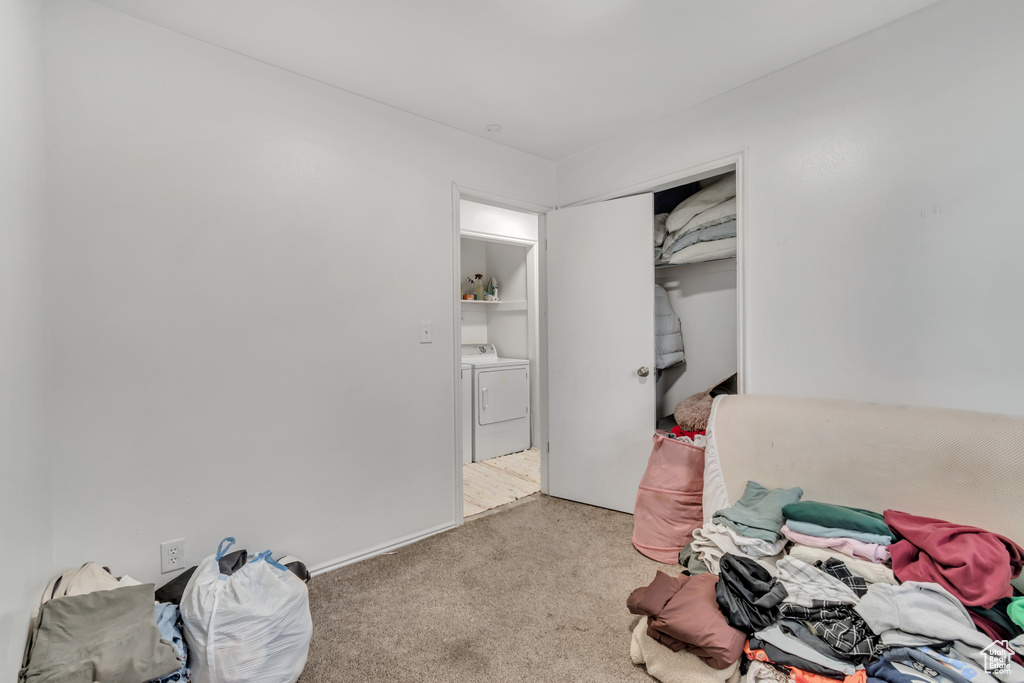 Carpeted bedroom featuring a closet and washer and clothes dryer