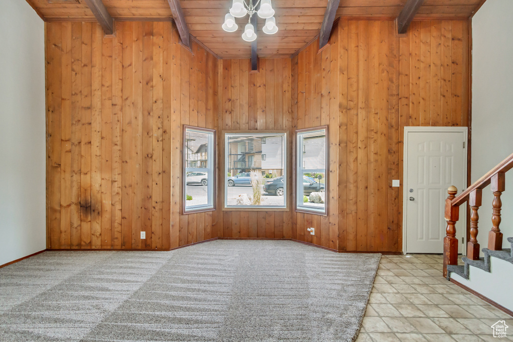 Entryway featuring wood walls, lofted ceiling with beams, a chandelier, and wooden ceiling