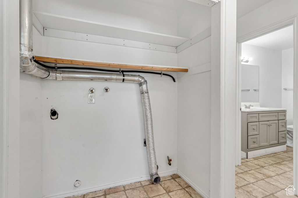 Clothes washing area featuring electric dryer hookup, gas dryer hookup, light tile floors, and hookup for a washing machine