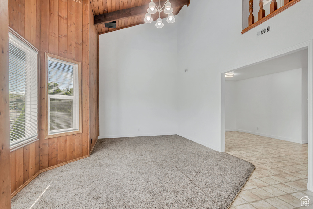 Tiled spare room with high vaulted ceiling, wooden ceiling, a notable chandelier, and beamed ceiling