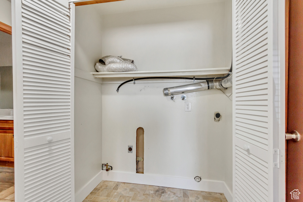 Laundry room featuring light tile patterned flooring and hookup for an electric dryer