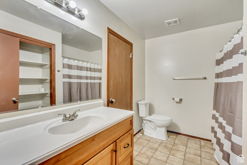 Bathroom with tile patterned floors, vanity, and toilet