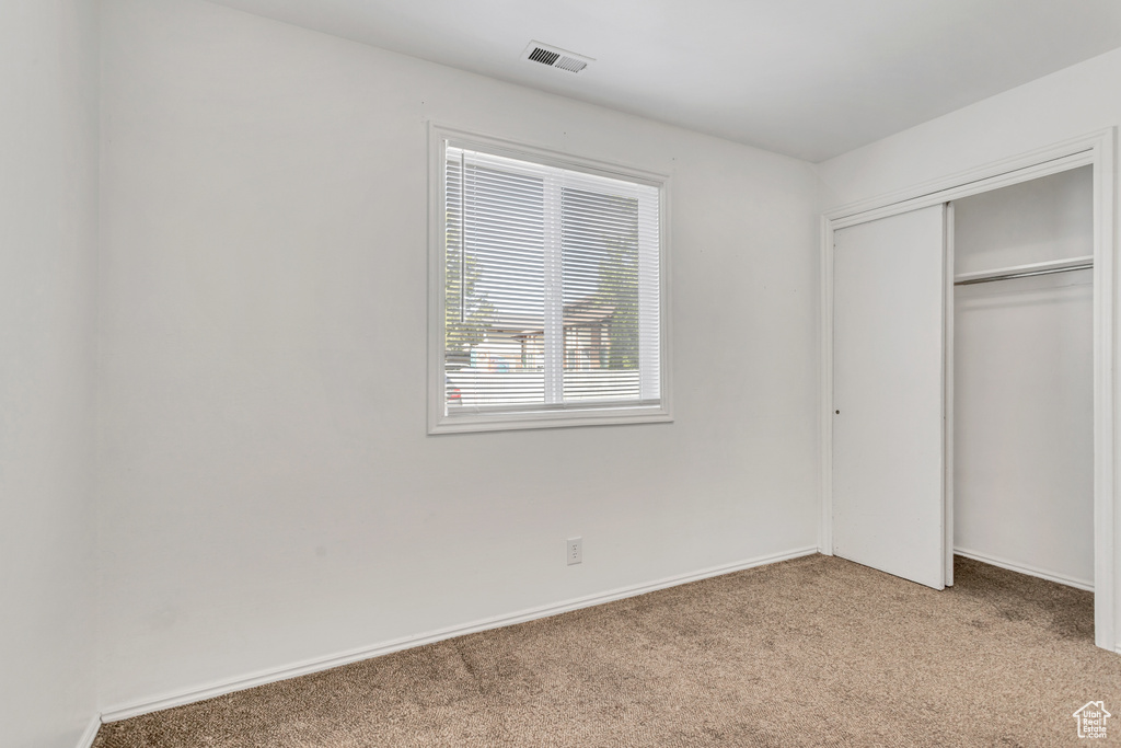 Unfurnished bedroom with a closet and carpet