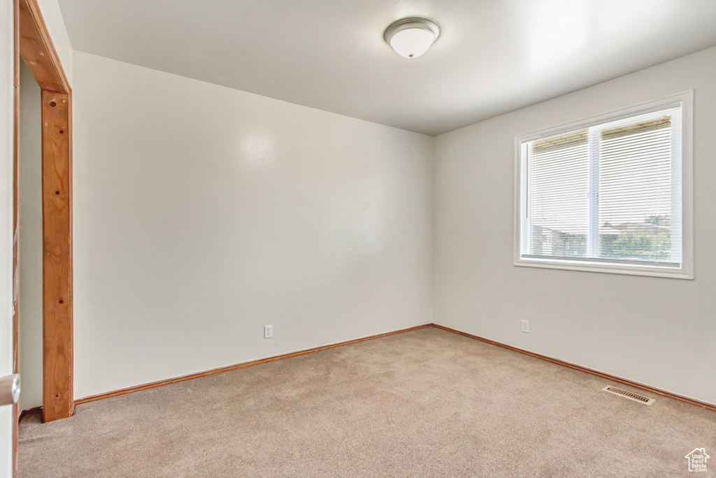 Empty room featuring light carpet