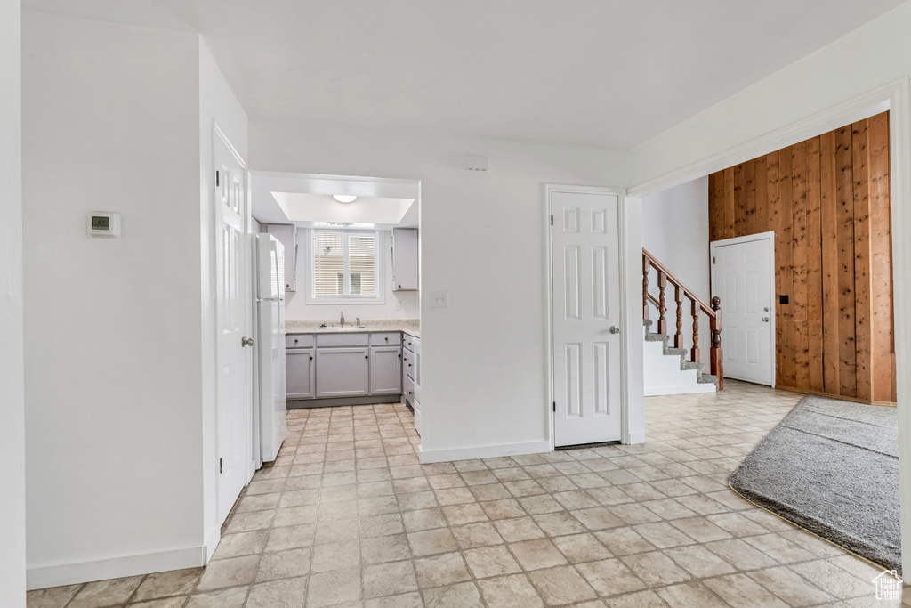 Interior space with sink, white fridge, and light tile floors