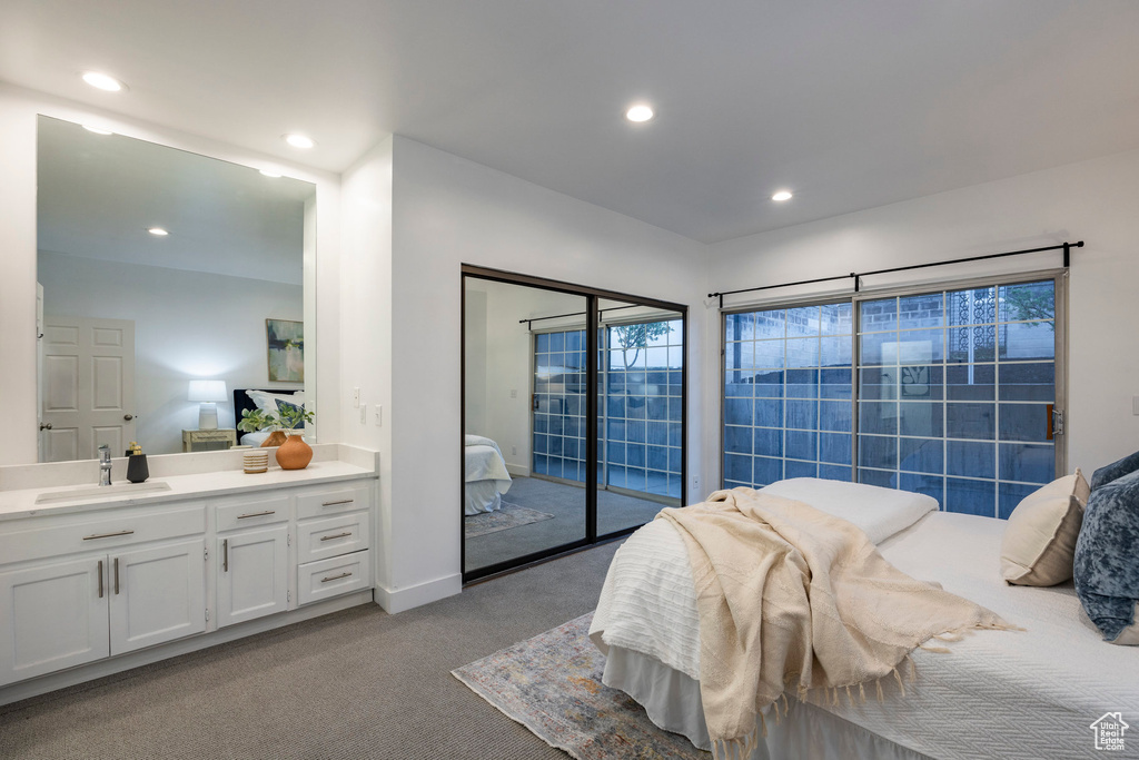 Bedroom with carpet floors, sink, and access to outside