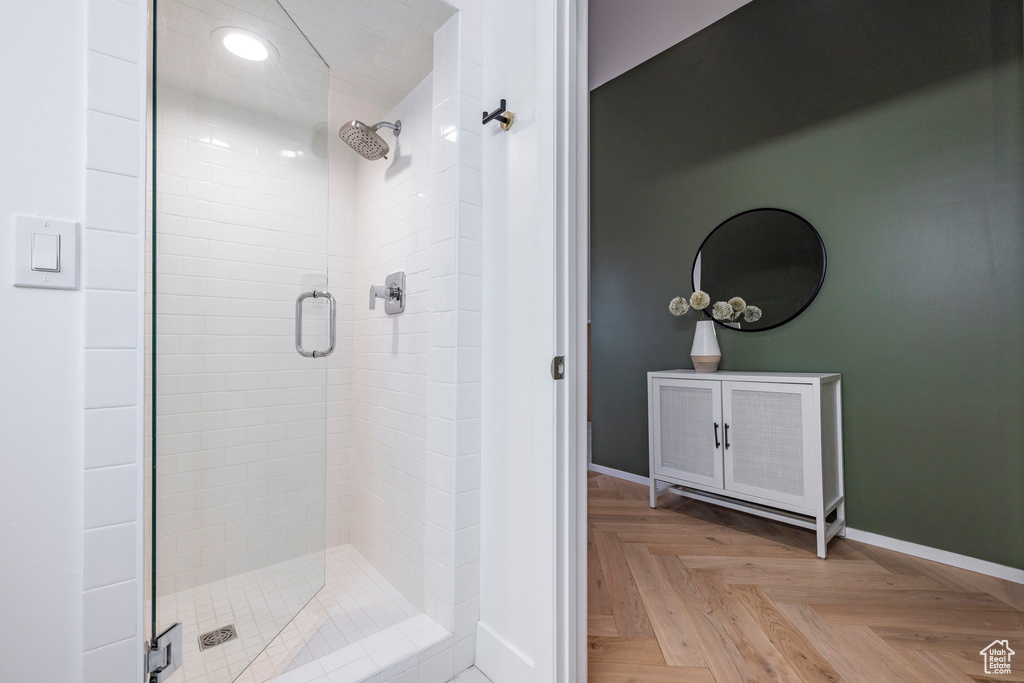 Bathroom with a shower with shower door and parquet floors