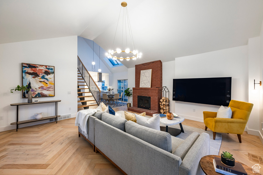 Living room with a fireplace, brick wall, a chandelier, and light parquet flooring