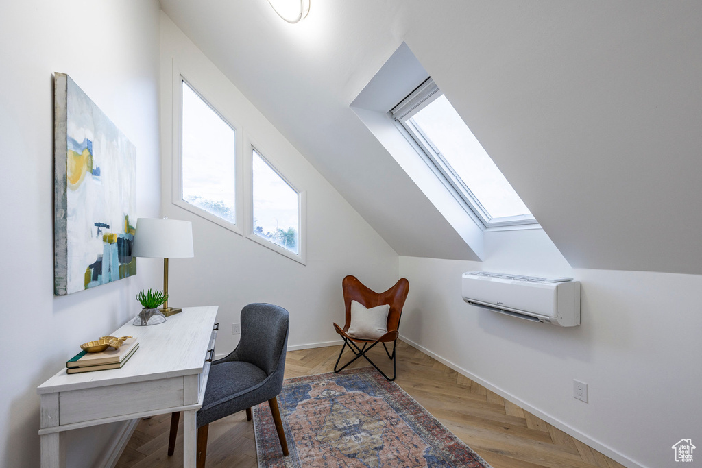 Office area with a wall mounted AC, lofted ceiling with skylight, and parquet floors