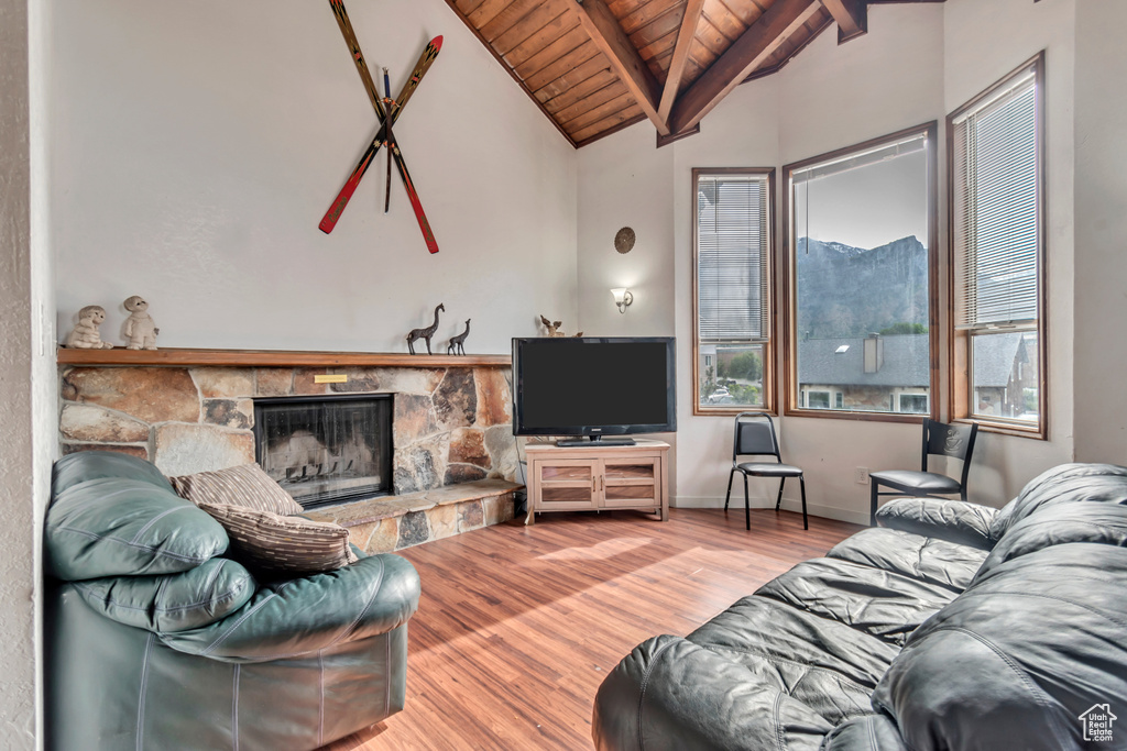 Living room featuring wooden ceiling, hardwood / wood-style flooring, a fireplace, and a wealth of natural light