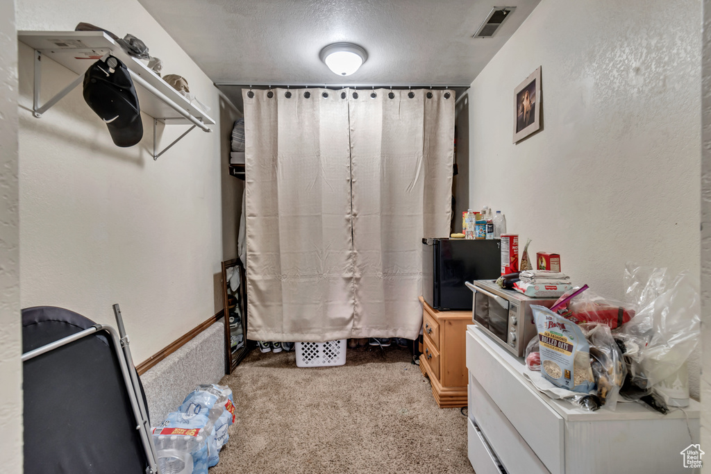 Spacious closet with light colored carpet