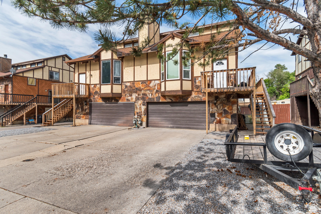 View of front of property with a garage and a wooden deck