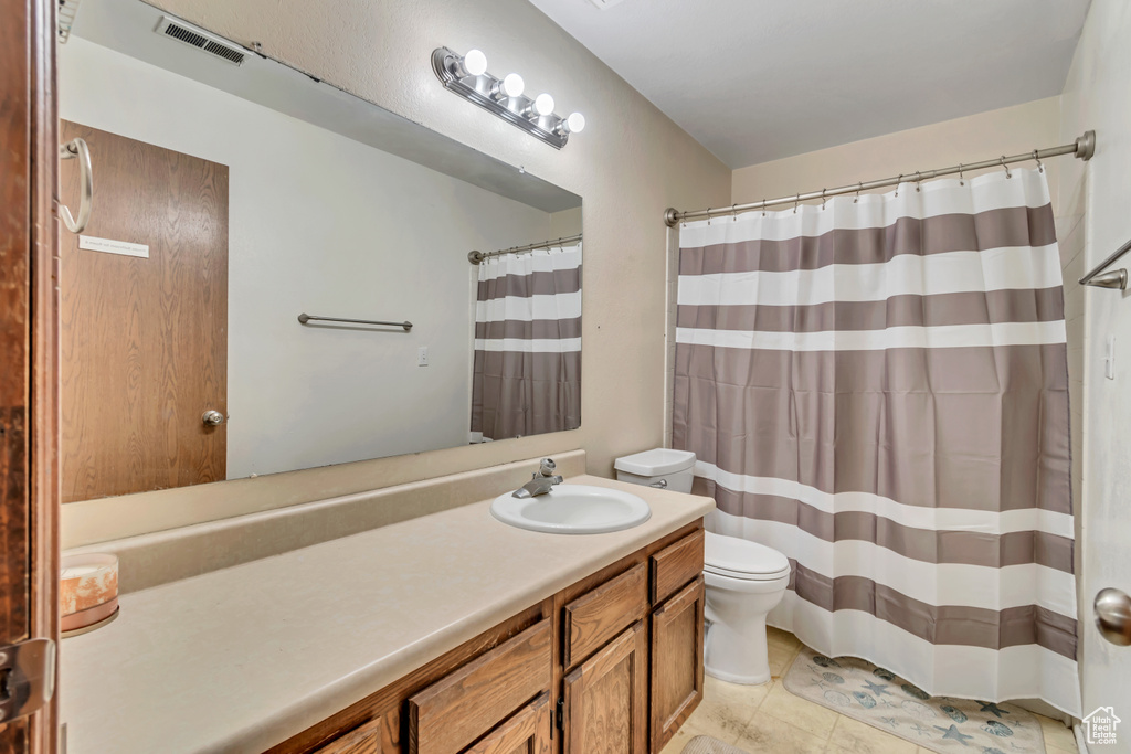 Bathroom with tile flooring, oversized vanity, and toilet