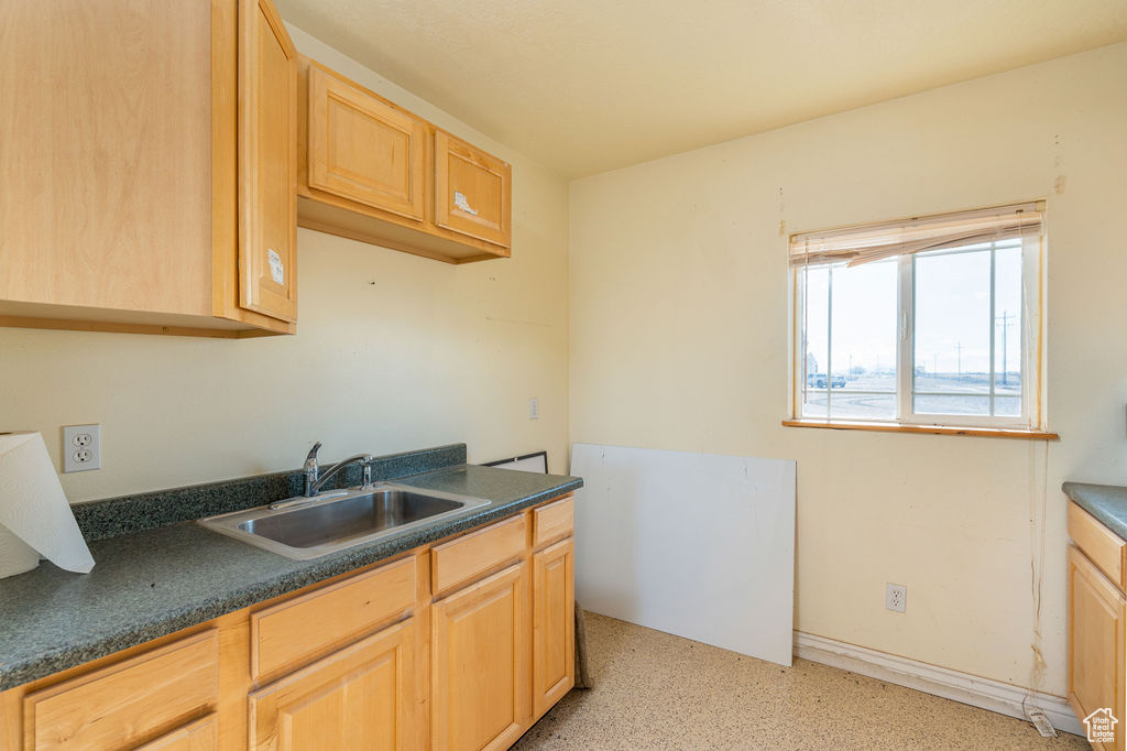 Kitchen with light brown cabinets and sink