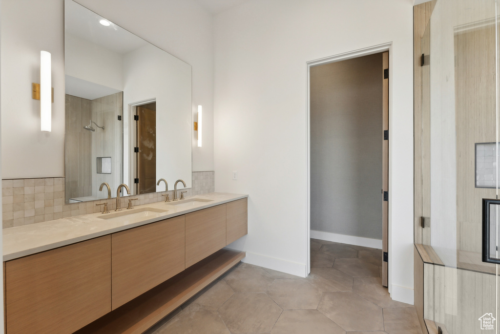 Bathroom with vanity, tile patterned floors, and tiled shower