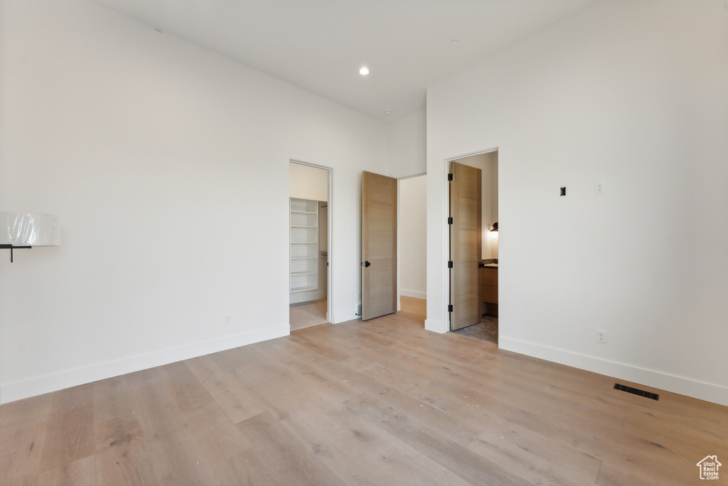 Empty room featuring a high ceiling and light hardwood / wood-style flooring