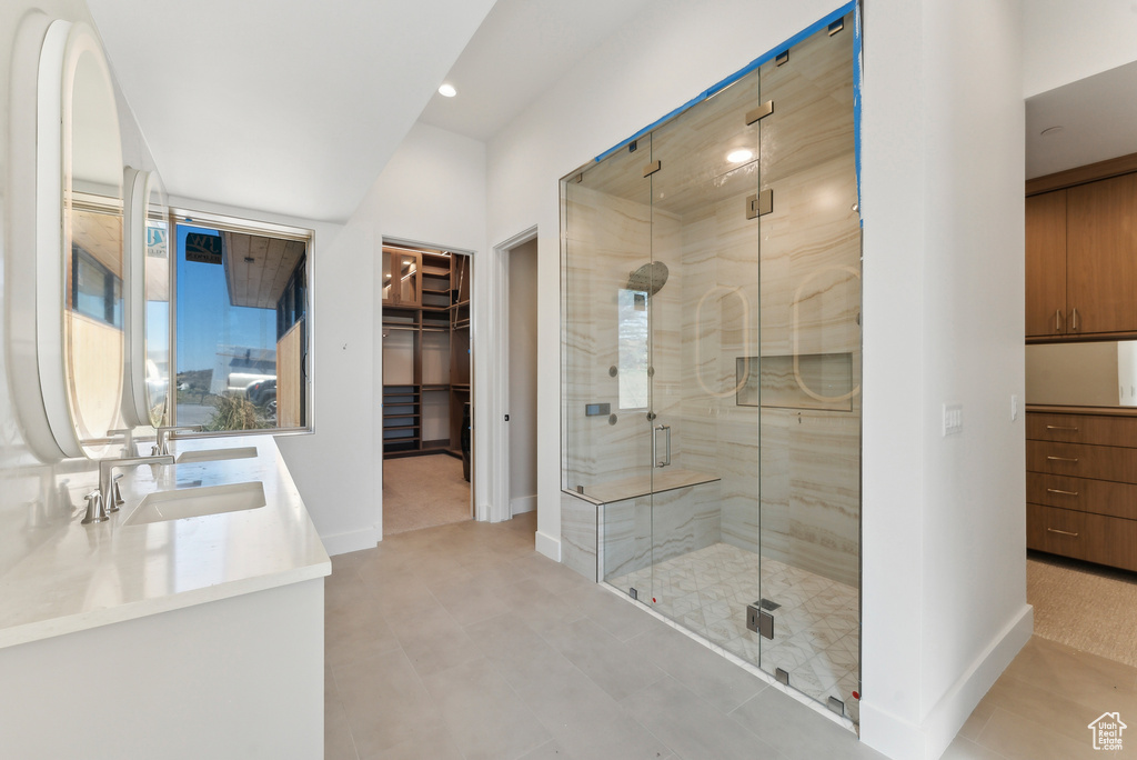 Bathroom featuring a shower with door and vanity