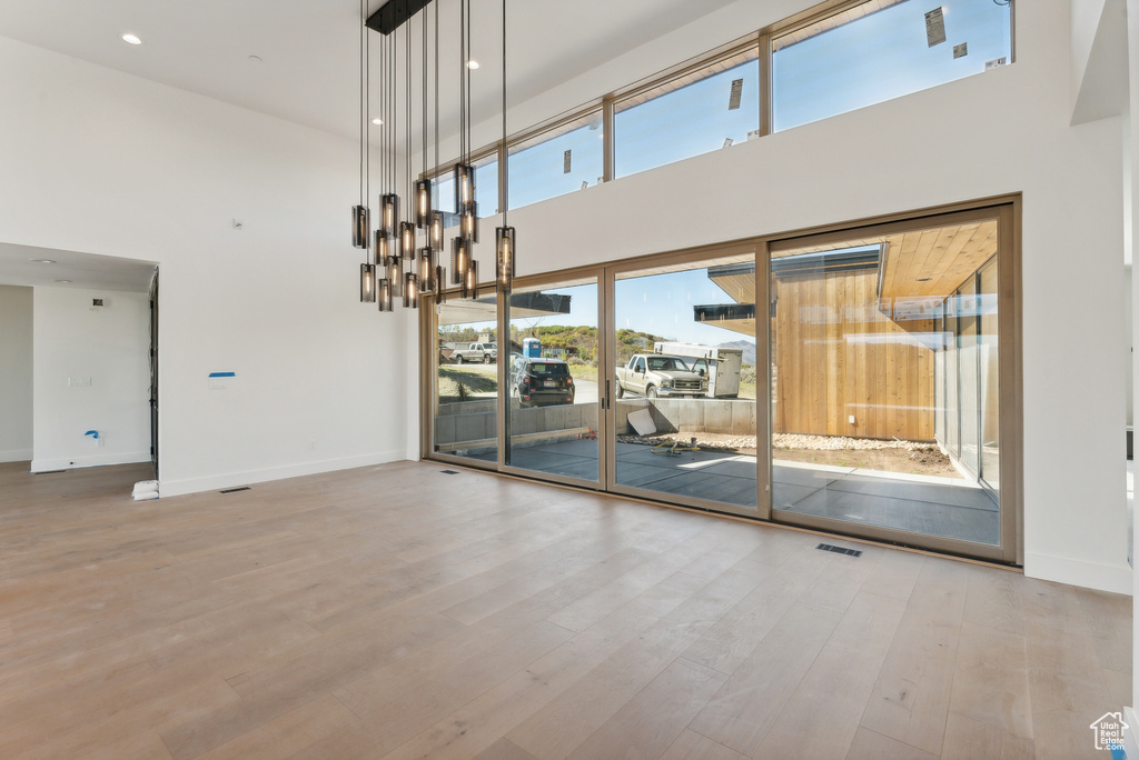 Unfurnished room with a high ceiling and light hardwood / wood-style floors