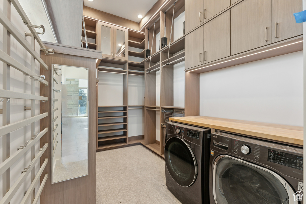 Washroom with washing machine and clothes dryer and light colored carpet